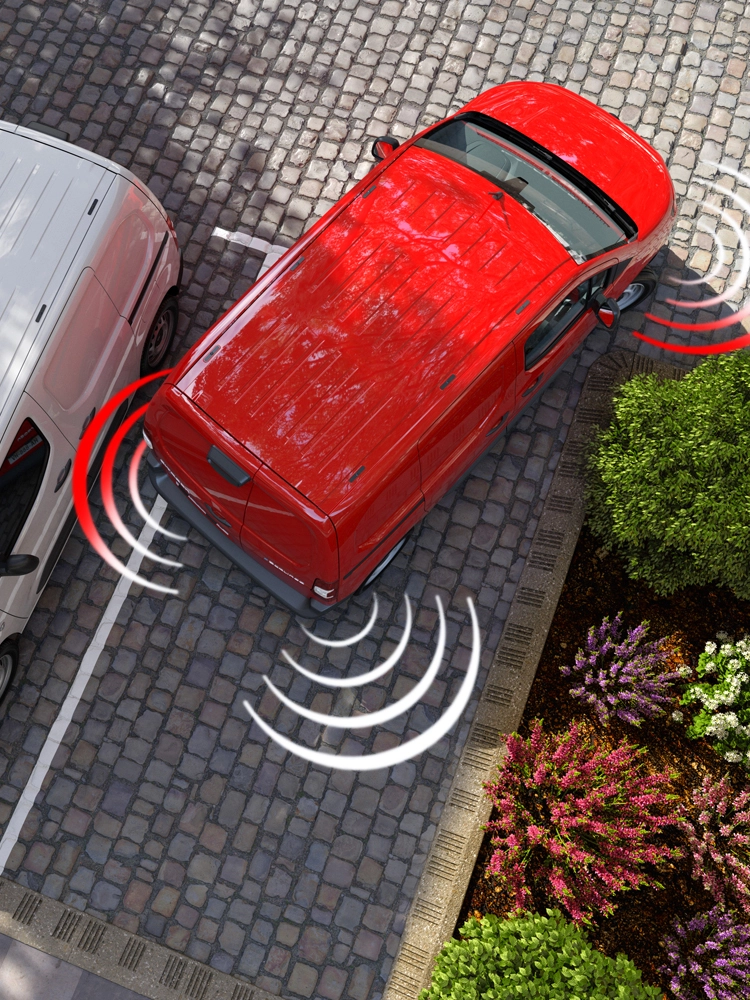 Vue aérienne d’un Berlingo Van utilisant les capteurs de stationnement avant et arrière pour détecter les obstacles dans un environnement urbain.