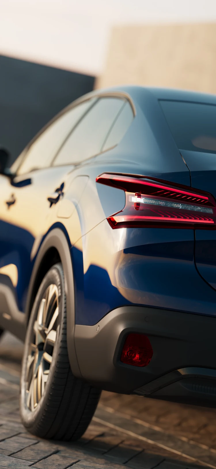 Gros plan du design du feu arrière Citroën ë-C4 X éclairé dans un éclairage chaleureux de coucher de soleil